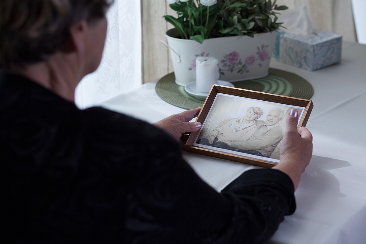 Picture of a lonely widow holding a photo from her past.