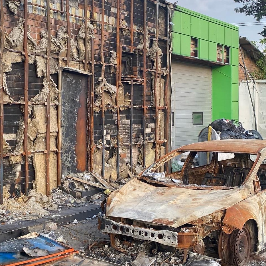 A burned building and car in Ukraine.