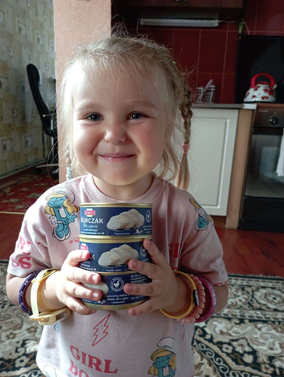Ukrainian girl smiling because of food donations.