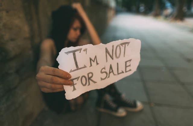 Teen girl holding sign I'm NOT for sale.
